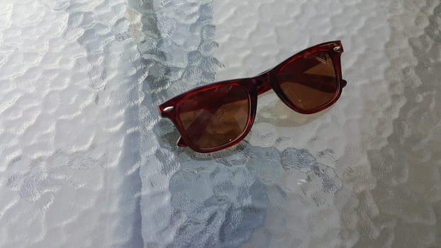 Eye glasses or spectacles on glass floor or table shining in the light