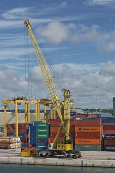 Dublin, Ireland - June 6, 2017: Large industrial cranes loading container ship in Dublin Port in Ireland.