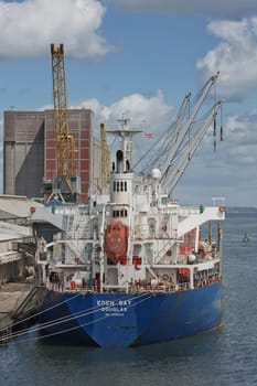 Belfast, Ireland - June 9, 2017: Large industrial cranes loading container ship in Belfast Port in Ireland.