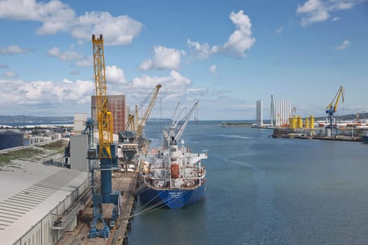 Belfast, Ireland - June 9, 2017: Large industrial cranes loading container ship in Belfast Port in Ireland.