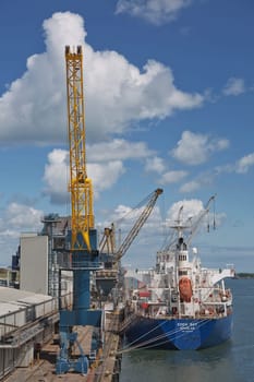 Belfast, Ireland - June 9, 2017: Large industrial cranes loading container ship in Belfast Port in Ireland.