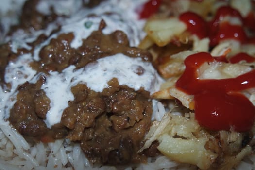 Delicious traditional dish of rice with potato fries and cereals with red ketchup. Food background with copy space for text and advertisements.