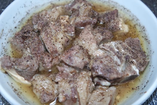 Top view of siri paaye or paya dish garnished with diced ginger, long coriander and black pepper. This dish is popular in Pakistan and Bangladesh