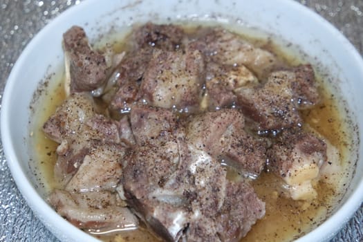 Top view of siri paaye or paya dish garnished with diced ginger, long coriander and black pepper. This dish is popular in Pakistan and Bangladesh