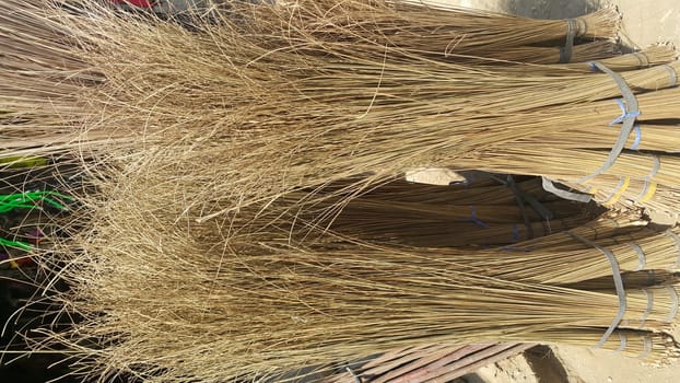 Bunch of brown colored straw broom. Old style broom used for housekeeping in rural area in Asian countries.