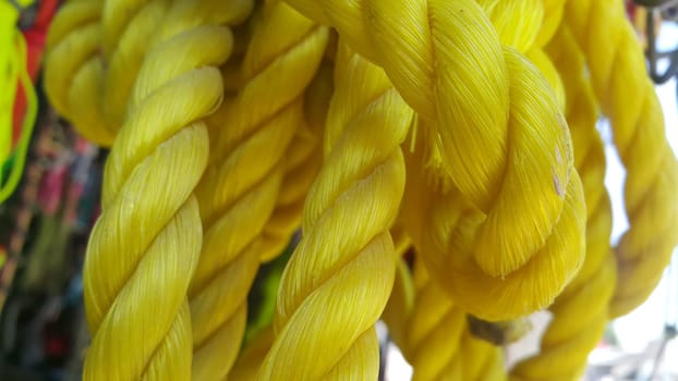 Closeup of bright color braided plastic ropes. Hanks or coil of bright colored plastic rope interwoven which are used for climbing and tightening materials.