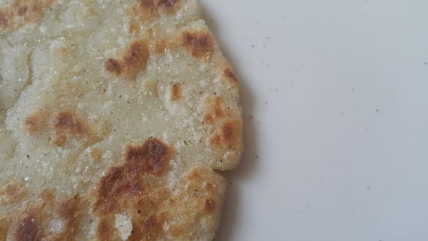 Closeup view of of traditional bread called Jawar roti or bhakri on white background. Bhakri is a round flat unleavened bread often used in the cuisine of many Asian countries
