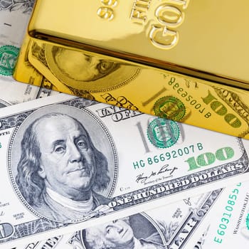 Gold metal ingot on the background of dollar bills
