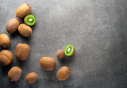 Ripe whole kiwi fruit and half kiwi fruit on grey table background