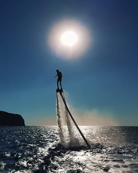 The man on the flyboard. Sea fun by the shore.