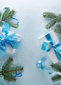 Holidays blue winter background with fir tree and gift box. Top view with copy space