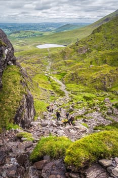 Killarney, Ireland, July 2019 Group of hikers climbing Devils Ladder, difficult trail, to reach highest Irish mountain Carrauntoohil, Ring of Kerry