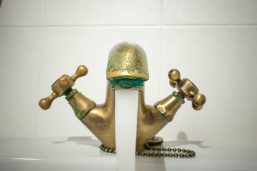 Open copper retro style basin faucet. Water jet