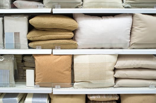 Bright pillows and bed wear on shelves. Selective focus
