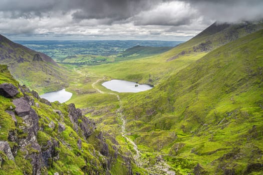 Group of hikers climbing Devils Ladder, one of most difficult trails, to reach highest Irish mountain Carrauntoohil in Ring of Kerry, Ireland