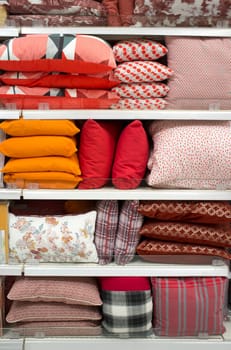 Colorful pillows and bed wear on shelves. Selective focus