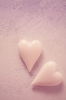 Two glass hearts on stone background in vintage pastel colors - soft focus. Symbol of love. Space for text.