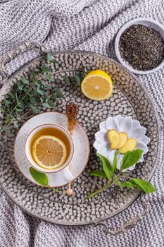 Healthy detox ginger and sage tea with lemon on tray