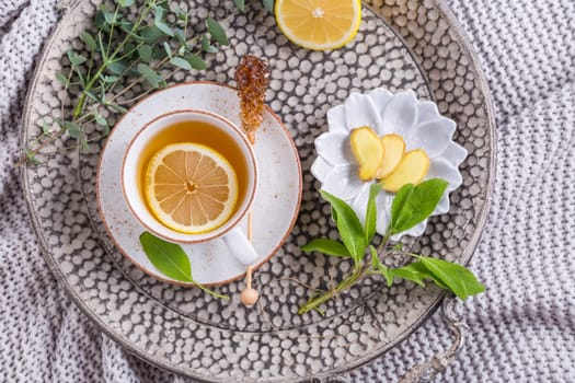 Healthy detox ginger and sage tea with lemon on tray