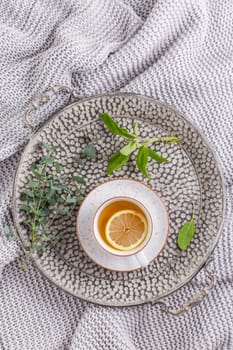 Healthy detox ginger and sage tea with lemon on tray