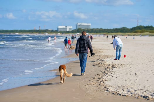 SWINOUJSCIE, POLAND – SEPTEMBER 10, 2020: Tourists walking on the beach of Swinoujscie on the Polish coast of the Baltic Sea