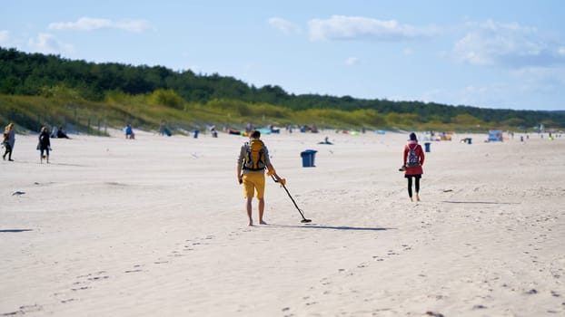 Treasure hunter with metal detector on the beach of Swinoujscie on the Polish Baltic coast
