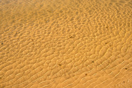 shallow surf with sand of a beach with patterns