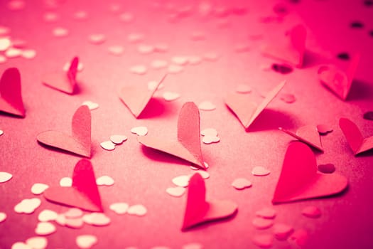 Red paper hearts on red background as background. Cocept of love and vValentine
