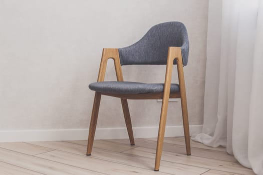 Modern grey chair with white brick walls on background and wood floor.