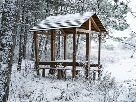 A beset for rest in the woods on the river bank in winter in the snow.