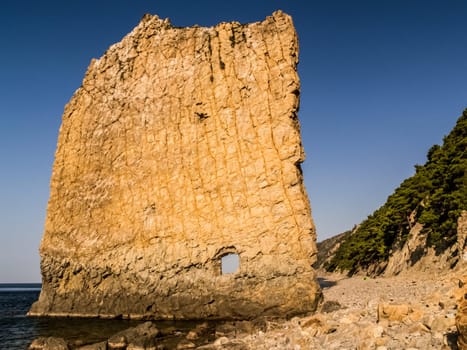 Rock sail with a hole. Rock by the Black Sea.