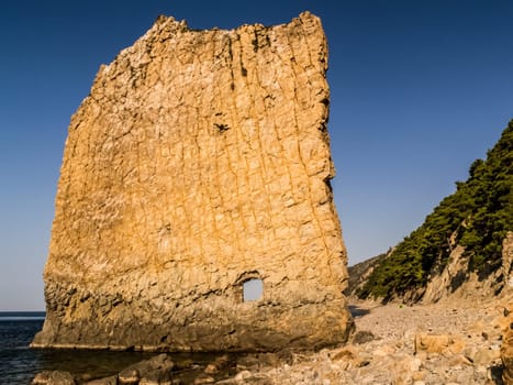 Rock sail with a hole. Rock by the Black Sea.