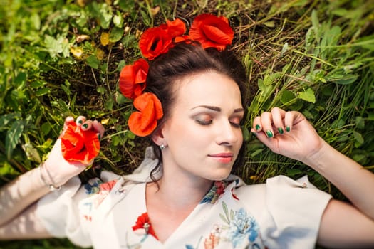 Beautiful girl with a wreath of red poppies.