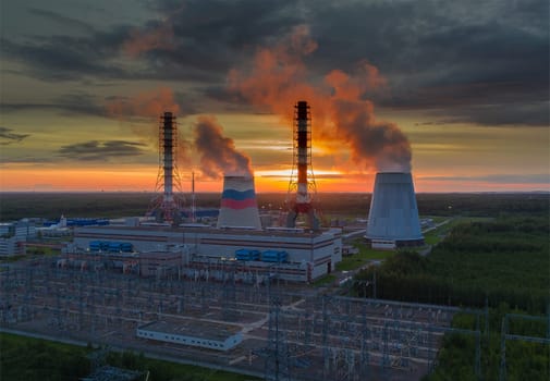 Steam from the power plant cooling towers. A view of the power plant pipes at sunset.