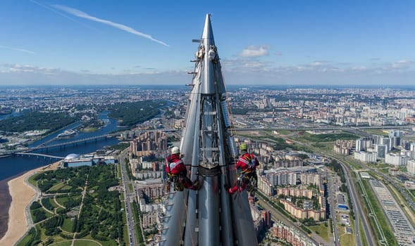 Workers installers at the height work at the top of the skyscraper.