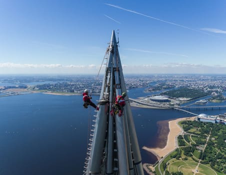 Workers installers at the height work at the top of the skyscraper.