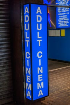 Adult cinema sex shop neon sign advertising a licensed business in the Soho red light district industry, stock image photo