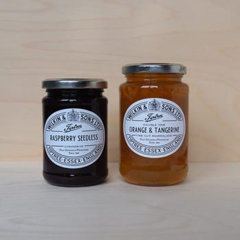 TIPTREE, UK - CIRCA DECEMBER 2020: Jar of Wilkin and Sons raspberry seedless conserve and orange and tangerine fine cut marmalade