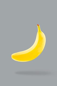 Minimal fruit concept. One whole banana with shadow. Illuminating colour fruits on ultimate gray background. Design element. Full depth of field.