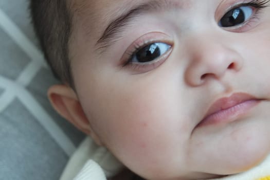 Baby girl with lovely face, big eyes and cute face gesture. Toddler baby making sweet activities