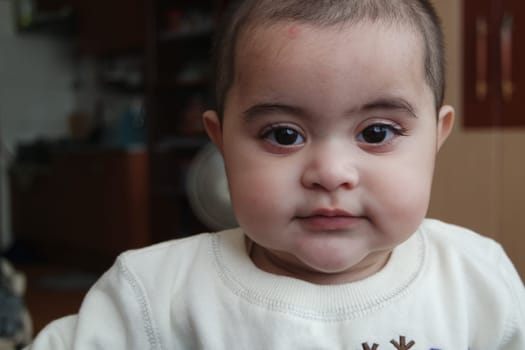 Baby girl with lovely face, big eyes and cute face gesture. Toddler baby making sweet activities