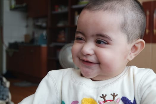 Baby girl with lovely face, big eyes and cute face gesture. Toddler baby making sweet activities