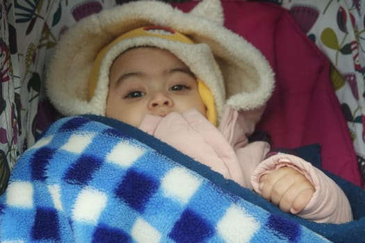 Baby girl with lovely face, big eyes and cute face gesture. Toddler baby making sweet activities