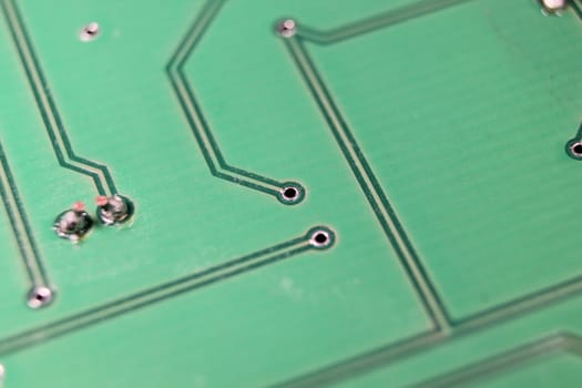 Electronic board with circuit lines and chip. Macro view of green board