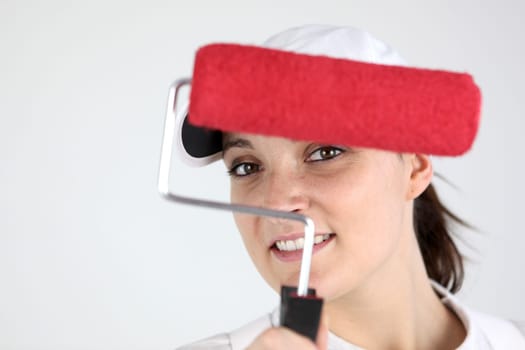 Woman holding roller dipped in red paint