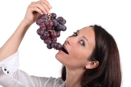 Brunette woman eating grapes