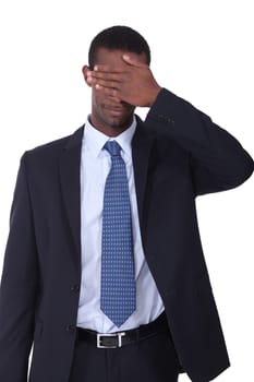 Man in a business suit with his hand covering his eyes