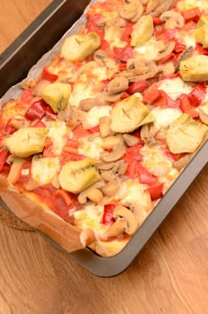 Pizza on a baking plate in a kitchen