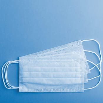 Medical mask surgical protective virus, flu, disease, textile filter. Isolated on a blue background.