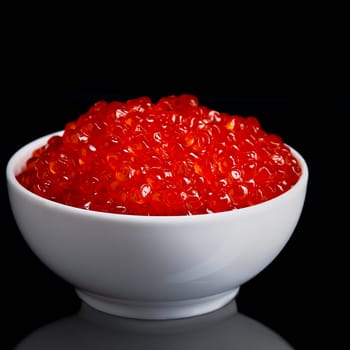 Red caviar in a white cup on a black background with a reflection. Place for advertisement, logo, label, mockup, mock-up.